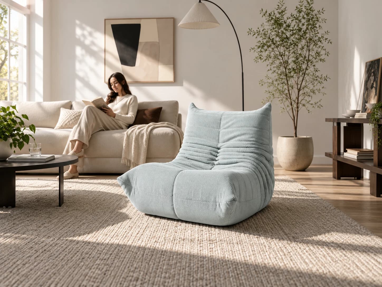 Sea Salt Caterpillar chair in a sunlit living room with a reader